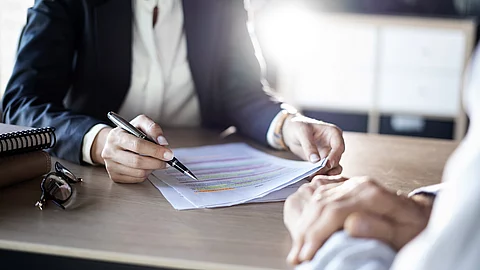 Zwei Business-Personen diskutieren über ein Dokument.