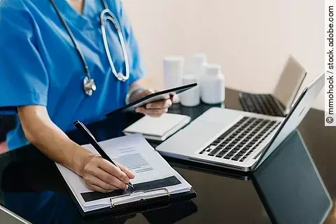 Eine Person sitzt an einem Schreibtisch.