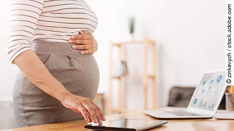 Eine schwangere Frau bedient ein Tablet.