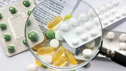 Eine Lupe wird über verschiedene Tabletten gehalten.