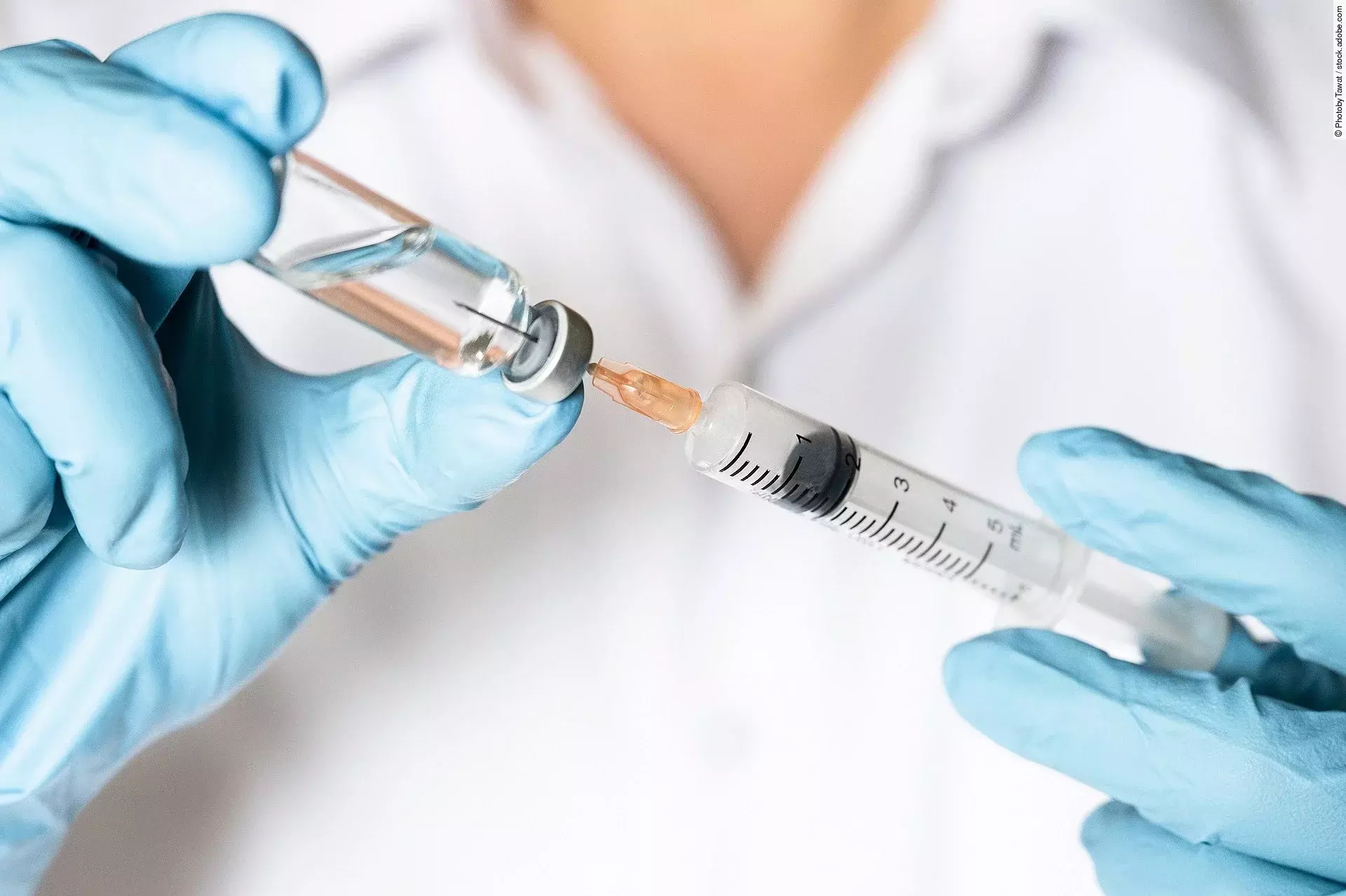 Ein*e Ärzt*in zieht eine Impfung auf.