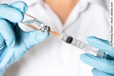 Ein*e Ärzt*in zieht eine Impfung auf.