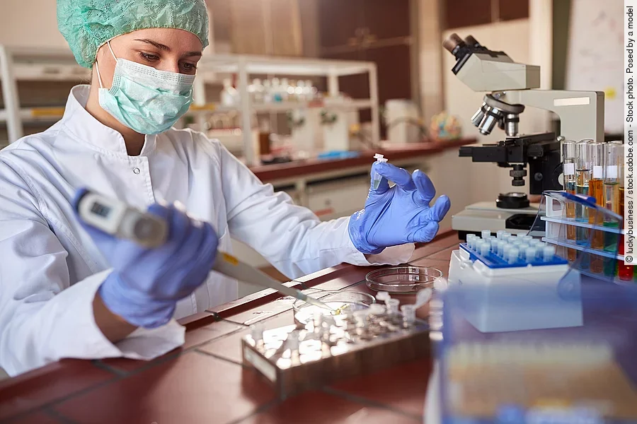 Eine Person arbeitet in einem Labor mit einer Pipette. 