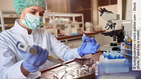 Eine Person arbeitet in einem Labor mit einer Pipette. 