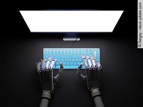 Roboter sitzt im Dunkeln an PC.