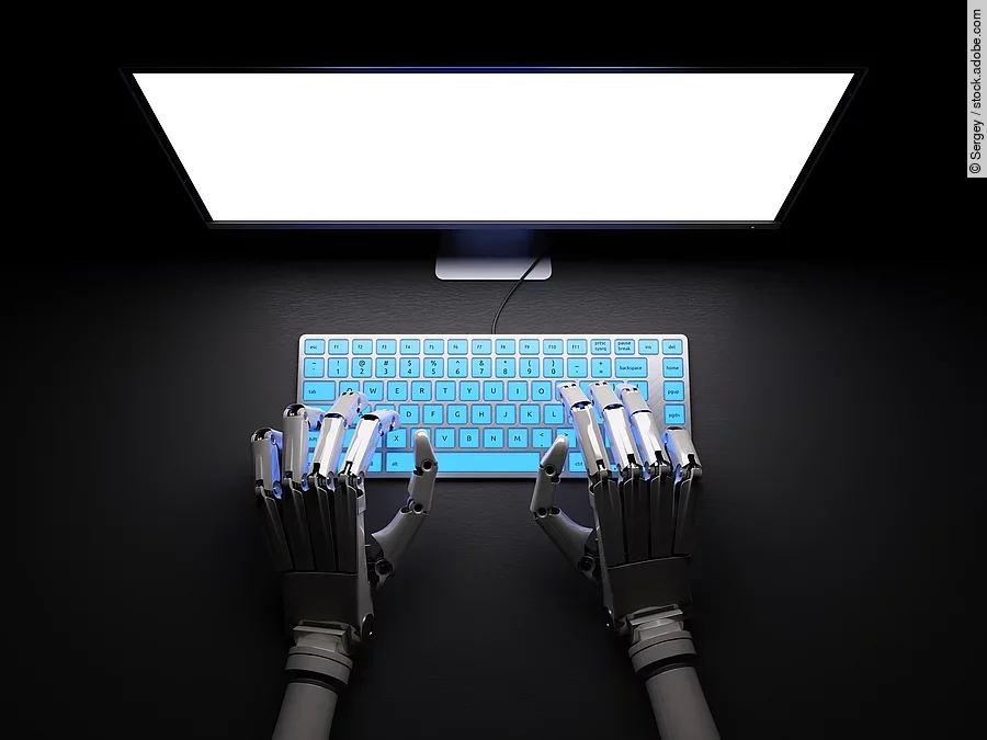 Roboter sitzt im Dunkeln an PC.