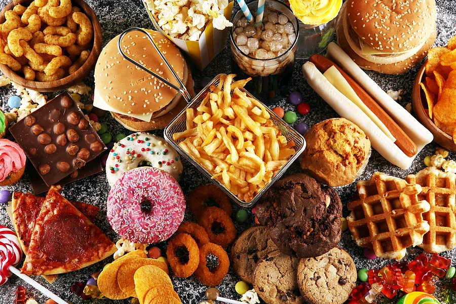 Ein Tisch ist voll mit verschiedenem Fastfood - vom Donuts über Pommes bis hin zu Burgern und Hot Dogs. Ein Tisch ist voll mit verschiedenem Fastfood - vom Donuts über Pommes bis hin zu Burgern und Hot Dogs.