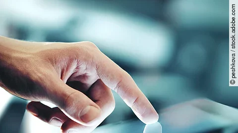 Eine Hand bedient ein Touchpad.