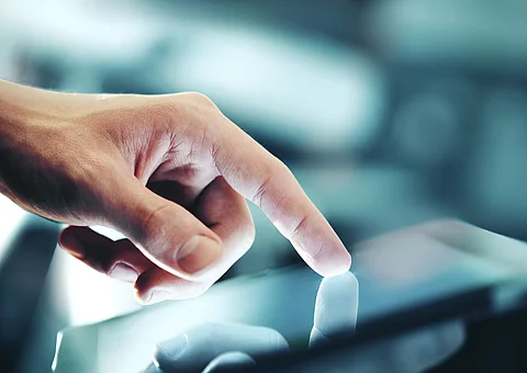 Eine Hand bedient ein Touchpad.