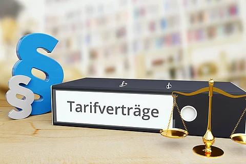 Tarifverträge – Recht/Gesetz. Ordner auf Schreibtisch neben Paragraf und Waage