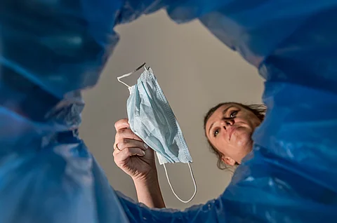 Frau wirft Mundschutz in Praxismülltonne