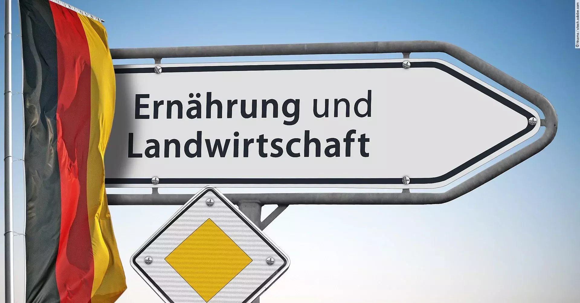 Ein weißes Straßenschild weist den Weg zum Bundesministerium für Ernährung und Landwirtschaft. Daneben hängt eine Deutschlandflagge.