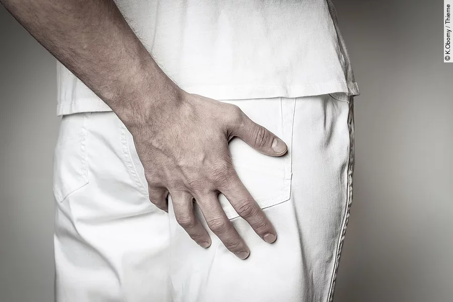 Eine Hand fasst an das Gesäß von einer anderen Person.