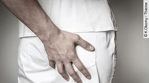 Eine Hand fasst an das Gesäß von einer anderen Person.