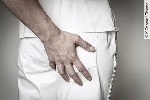 Eine Hand fasst an das Gesäß von einer anderen Person.