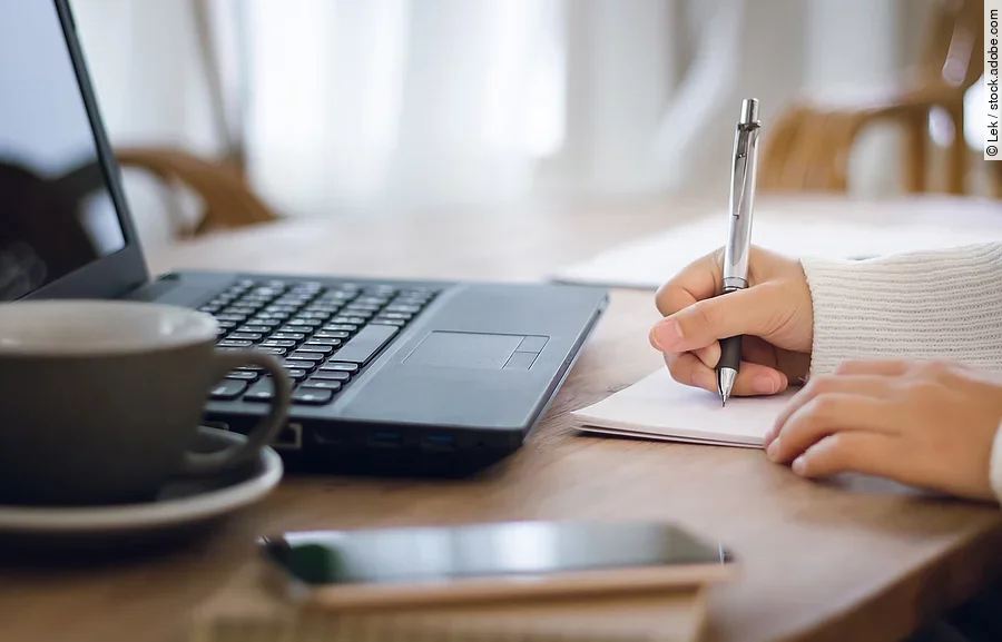 Nahaufnahme von einer am Schreibtisch arbeitenden Person.
