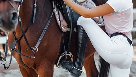Girl rider ready for climbs, woman legs in boots with horse in t
