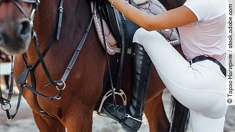 Girl rider ready for climbs, woman legs in boots with horse in t