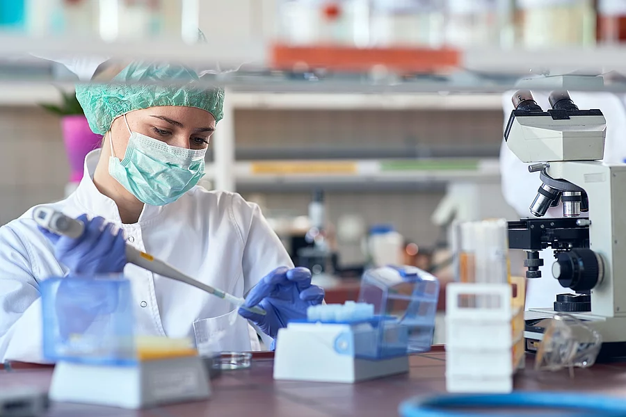 lab analysis of new corona virus, clinic laboratory chemical research of infection. Covid-19 concept. Eine Person sitzt in einem Labor und pipettiert.