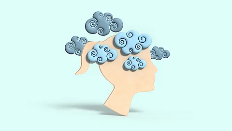 Eine Grafik zeigt auf einem türkisen Hintergrund einen beigen Frauenkopf in der Seitenperspektive mit Pferdeschwanz. Um den Kopf sind ganz viele dunkle Wolken, die eine psychische Belastung andeuten sollen.