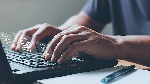 Nahaufnahme von einem Laptop an dem eine Person auf der Tastatur tippt.