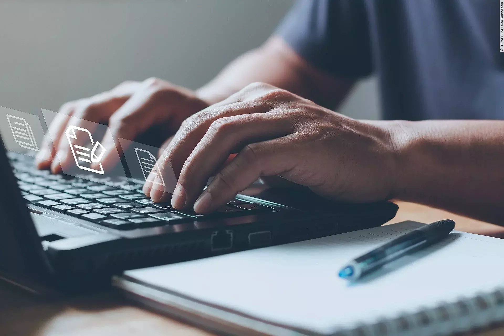 Nahaufnahme von einem Laptop an dem eine Person auf der Tastatur tippt.