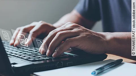 Nahaufnahme von einem Laptop an dem eine Person auf der Tastatur tippt.