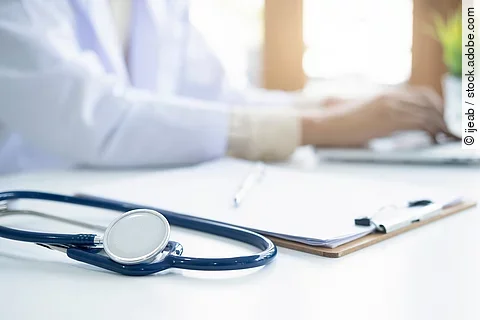 Eine medizinische Person arbeitet an einem Laptop.