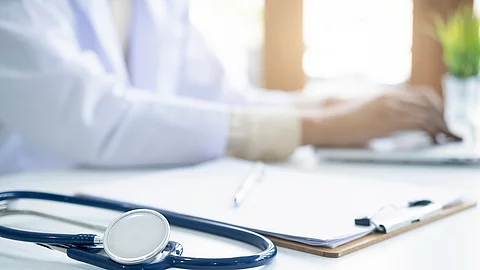 Eine medizinische Person arbeitet an einem Laptop.