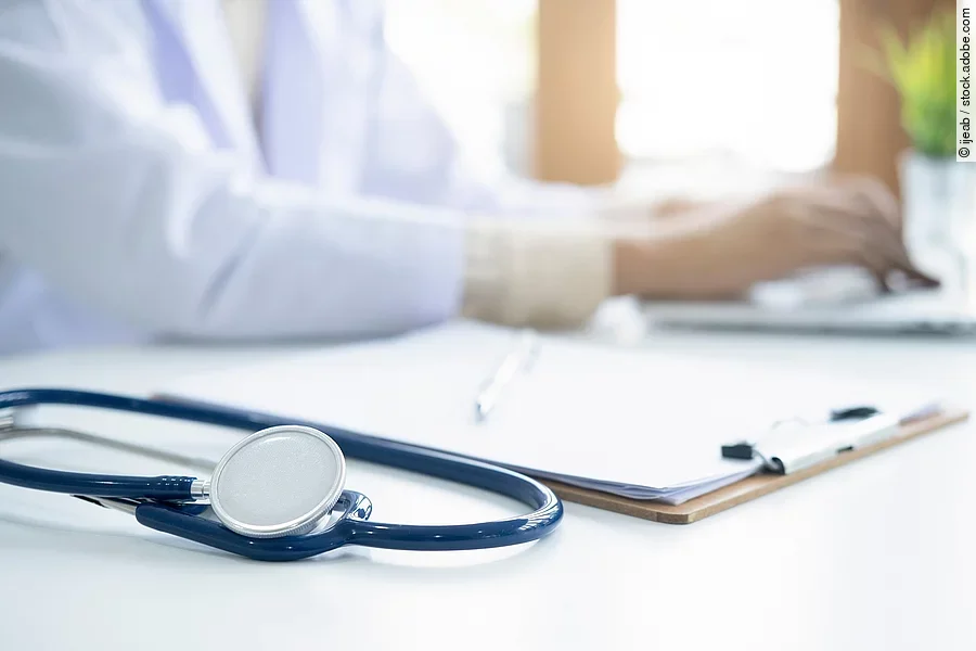 Eine medizinische Person arbeitet an einem Laptop.