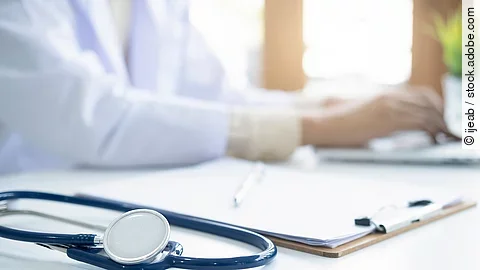 Eine medizinische Person arbeitet an einem Laptop.