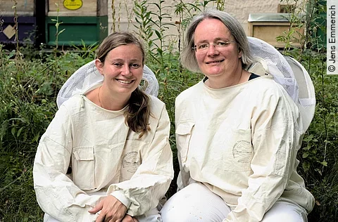 Dr. Julia Dittes und Dr. Ilka Emmerich in ihren weißen Imkeranzügen.