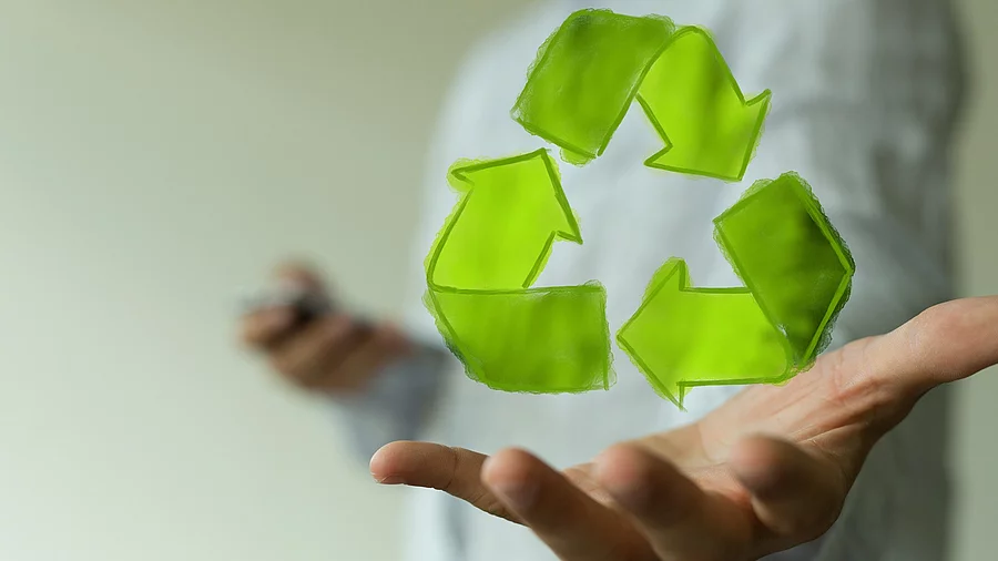 Recycling-Symbol schwebt vor einer offenen Hand Recycling-Symbol schwebt vor einer offenen Hand