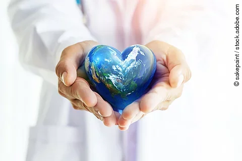 Ein Arzt in weißem Kittel hält die herzförmige Erde in seinen Händen.