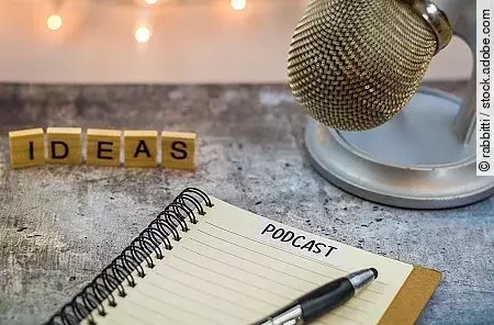 Podcast ideas concept with microphone, notepad, tablet on board