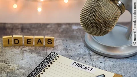 Podcast ideas concept with microphone, notepad, tablet on board