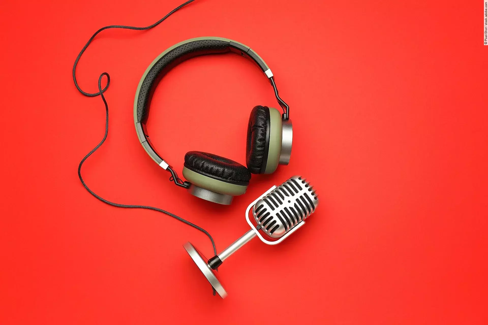 Kopfhörer und Mikrofon auf rotem Untergrund.