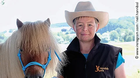 Nana Keck trägt einen beigen Cowboyhut und posiert mit einem braunen Pony für die Kamera. Nana Keck trägt einen beigen Cowboyhut und posiert mit einem braunen Pony für die Kamera.