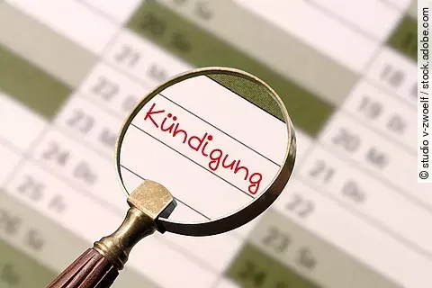 Eine Lupe wird über einen Jahreskalender gehalten. Durch die Lupe erkennt man einen Eintrag in den Kalender. In roter Schrift steht dort "Kündigung" geschrieben.