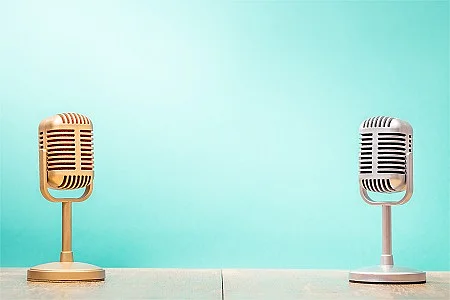 Golden and silver retro microphones on table front gradient mint green background. Vintage old style filtered photo