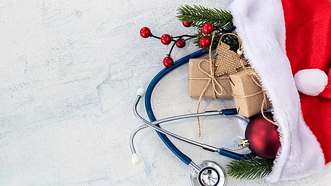 In einer Weihnachtsmütze sind kleine Geschenke, Tannenzweige und ein Stethoskop.