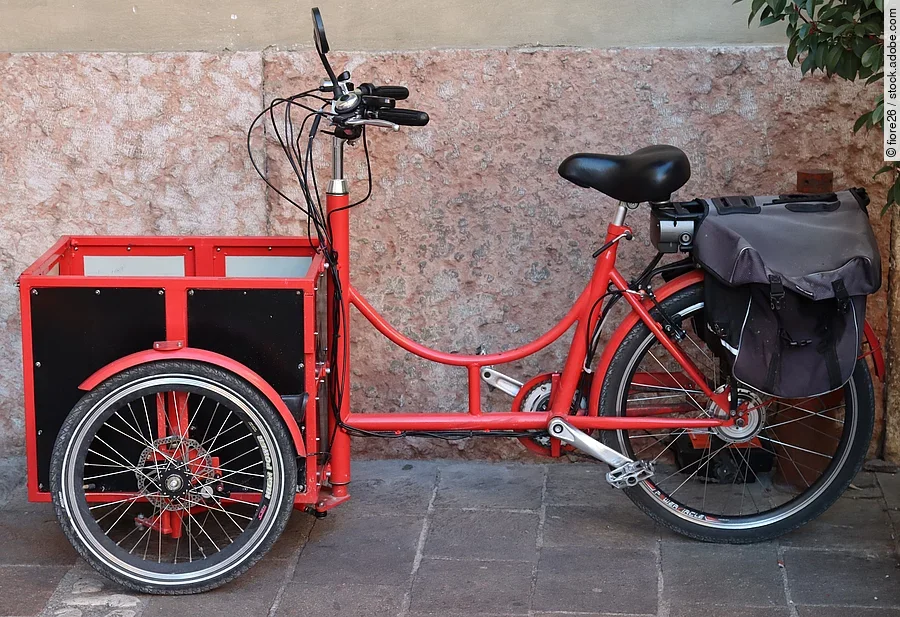 Seitliche Ansicht von einem roten Lastenrad.