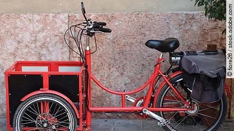 Seitliche Ansicht von einem roten Lastenrad.