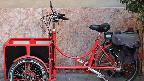 Seitliche Ansicht von einem roten Lastenrad.