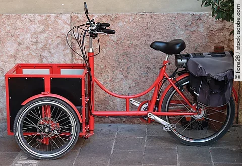 Seitliche Ansicht von einem roten Lastenrad.
