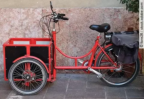 Seitliche Ansicht von einem roten Lastenrad.