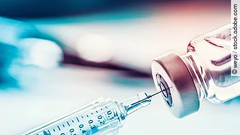 Nahaufnahme von einer Spritze in die Vakzine aufgezogen wird.