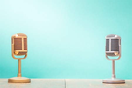 Golden and silver retro microphones on table front gradient mint green background. Vintage old style filtered photo