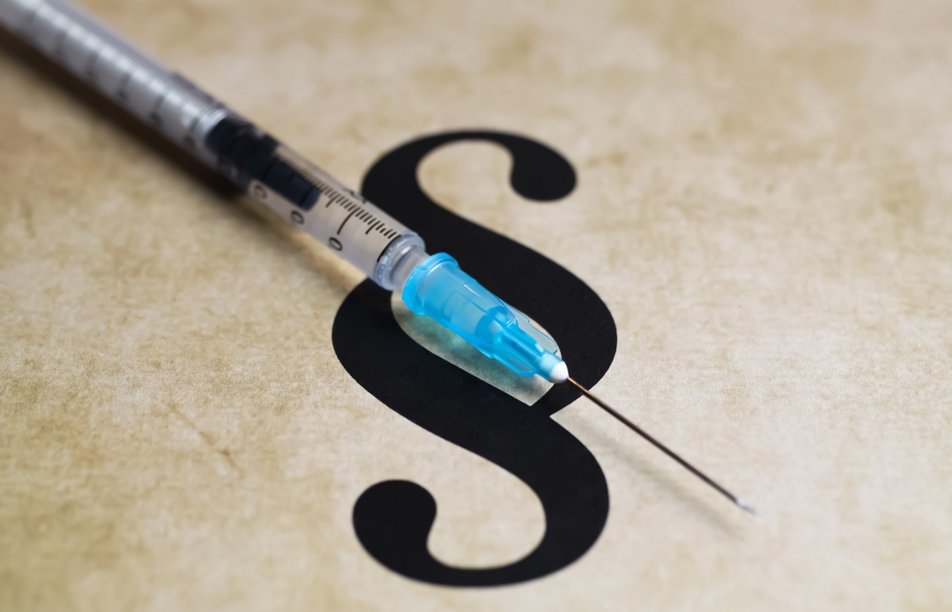 Closeup of paragraph symbol with vaccination syringe - mandatory