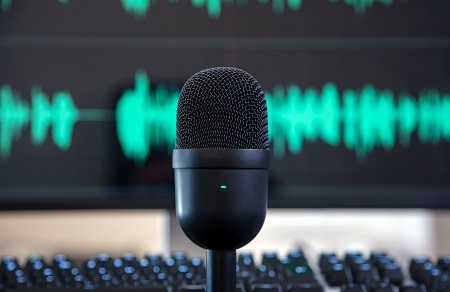 Black condenser microphone, blur turquoise waveform background.